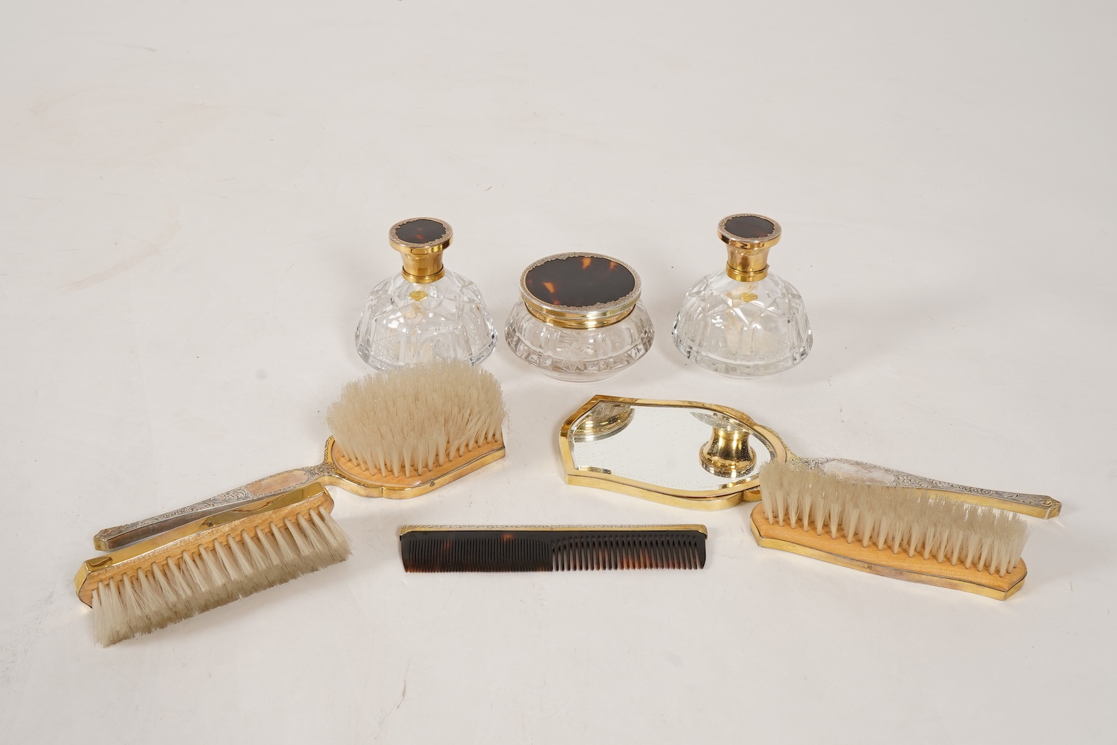 A mid 20th century continental eight piece gilt white metal and tortoiseshell mounted dressing table set